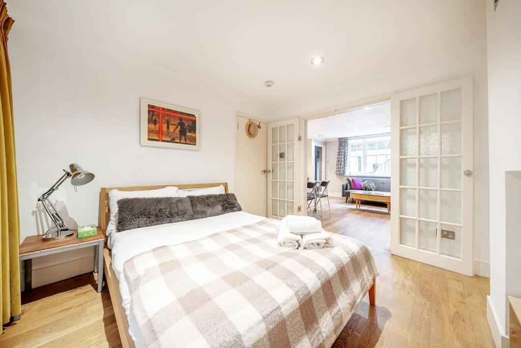 - une chambre avec un lit et une couverture en damier dans l'établissement Elegant Marylebone Hideaway, à Londres