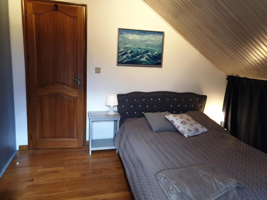 1 dormitorio con 1 cama y suelo de madera en Nature & bien-être, en Étival-Clairefontaine