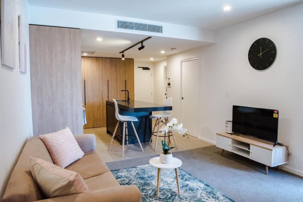 a living room with a couch and a table at Ideal Cozy 1BR for your Urban Escape in Gabba in Brisbane
