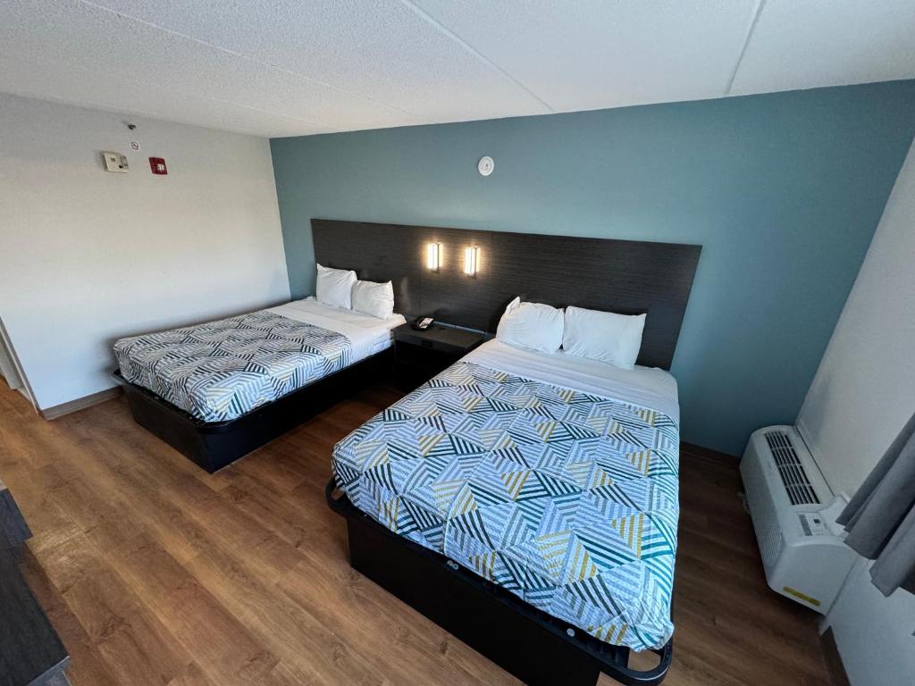 um quarto de hotel com duas camas num quarto em Motel 6 East Syracuse, NY - Airport em East Syracuse
