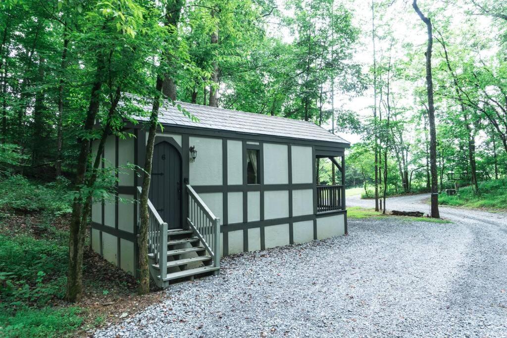 a small shed with a staircase in a forest at Tiny Home Cottage Near the Smokies #6 Greta in Sevierville