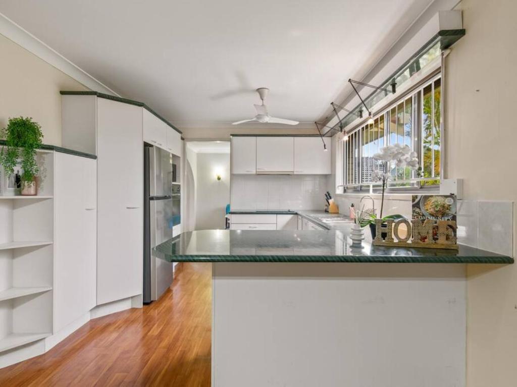 a kitchen with white cabinets and a green counter top at 5Mins walk to mall 4BR Family home nicely located in Brisbane