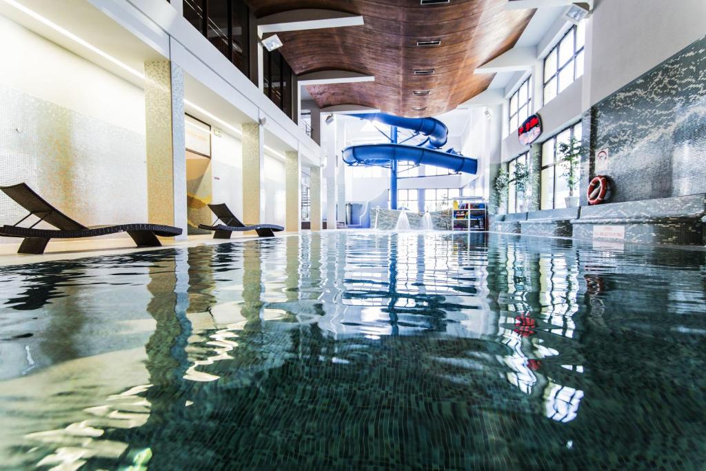 an indoor swimming pool in a building with water at Hotel Klimek Spa in Muszyna