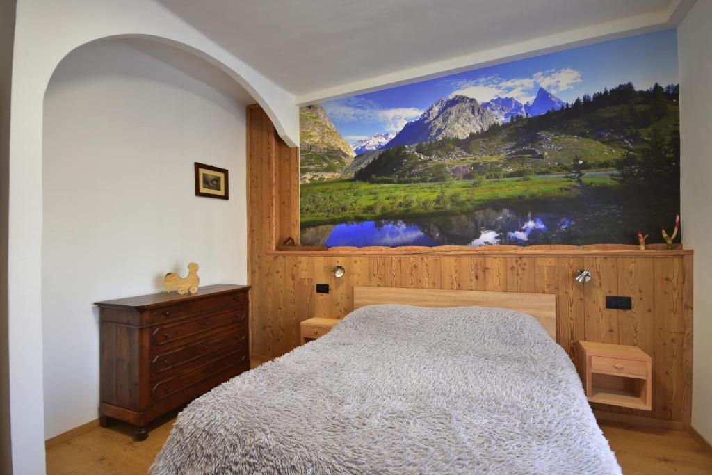 een slaapkamer met een bed met een schilderij aan de muur bij Ca' Elide in Aosta