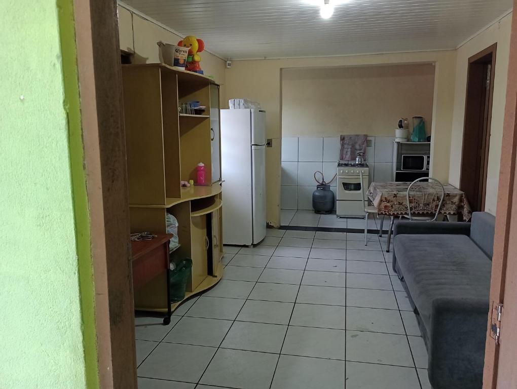因貝的住宿－Casa Imbé 100 MT do Mar，厨房配有冰箱、桌子和沙发