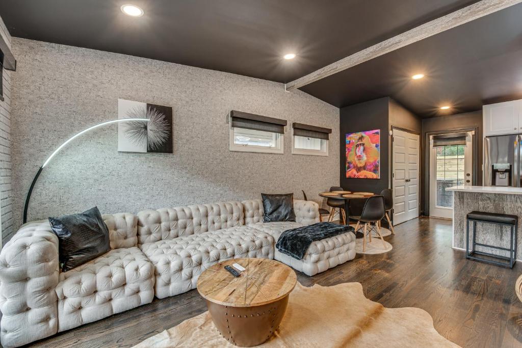ein Wohnzimmer mit einem weißen Sofa und einem Tisch in der Unterkunft Modern Atlanta Retreat Private Hot Tub and Yard! in Atlanta
