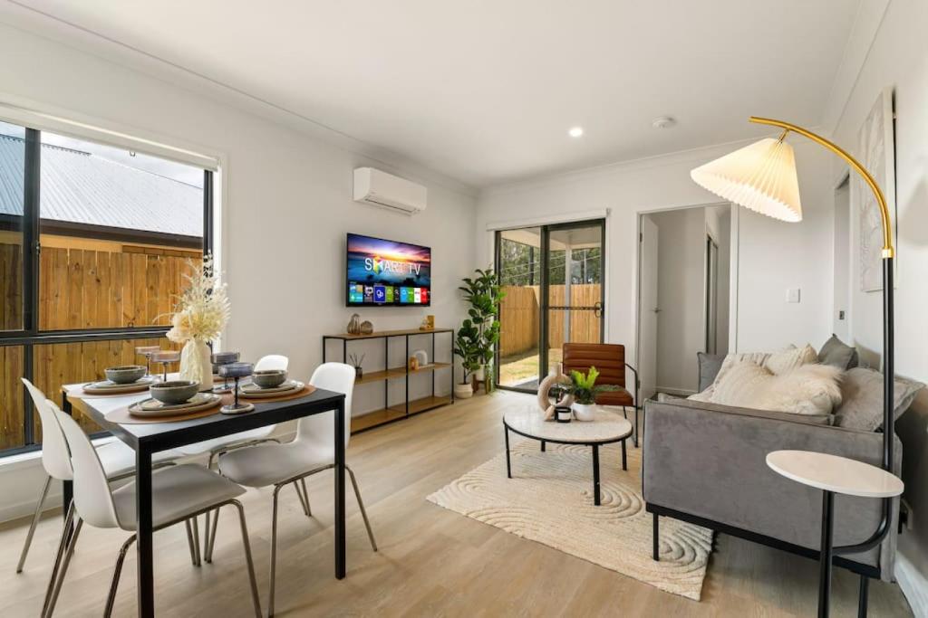 una sala de estar con un sofá y una mesa en Cozy 2BR brandnew home at Brown Plains, en Browns Plains