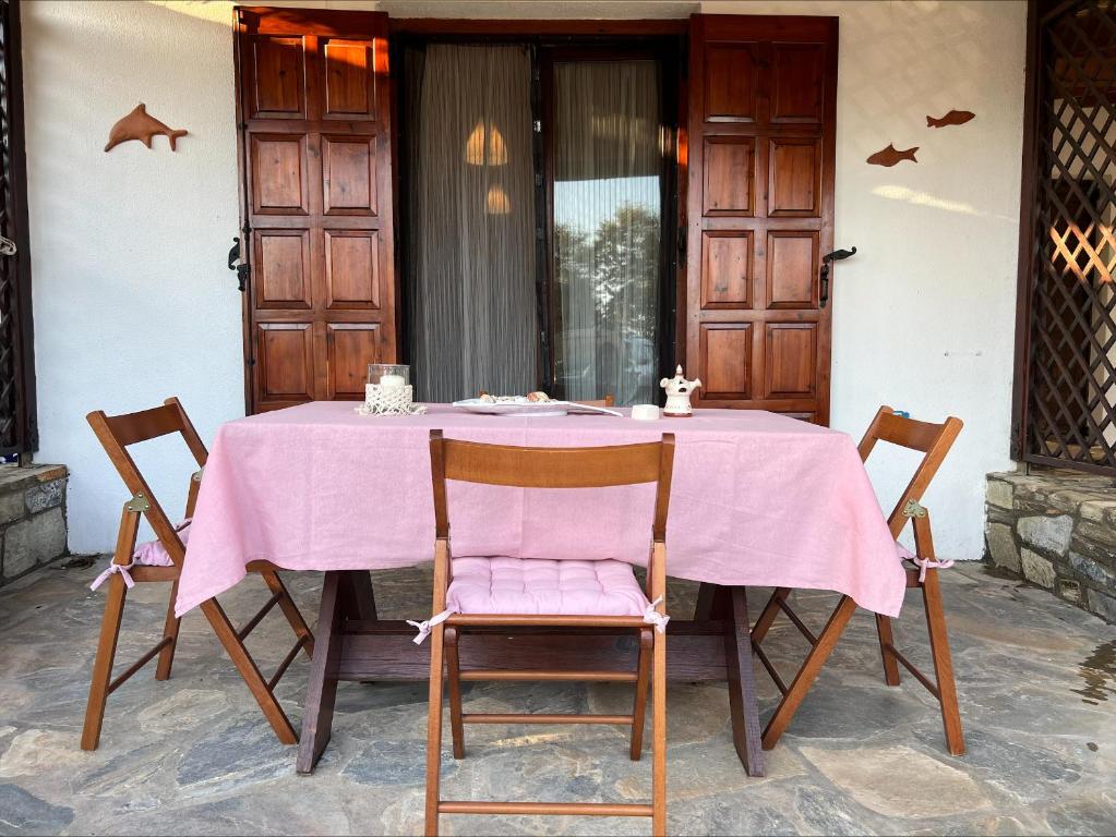 a table with a pink table cloth on it at Platanidia Guesthouse in Platanidia