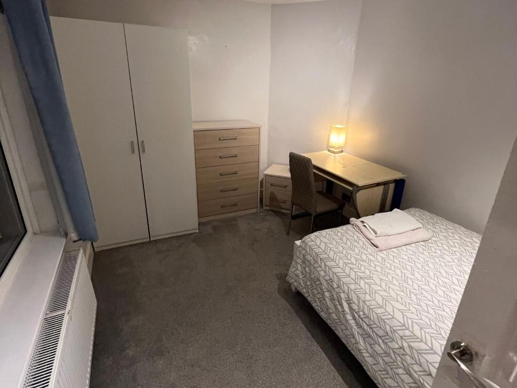 een slaapkamer met een bed en een bureau met een lamp bij Immaculate House for Professionals 2020 Renovation in Cove
