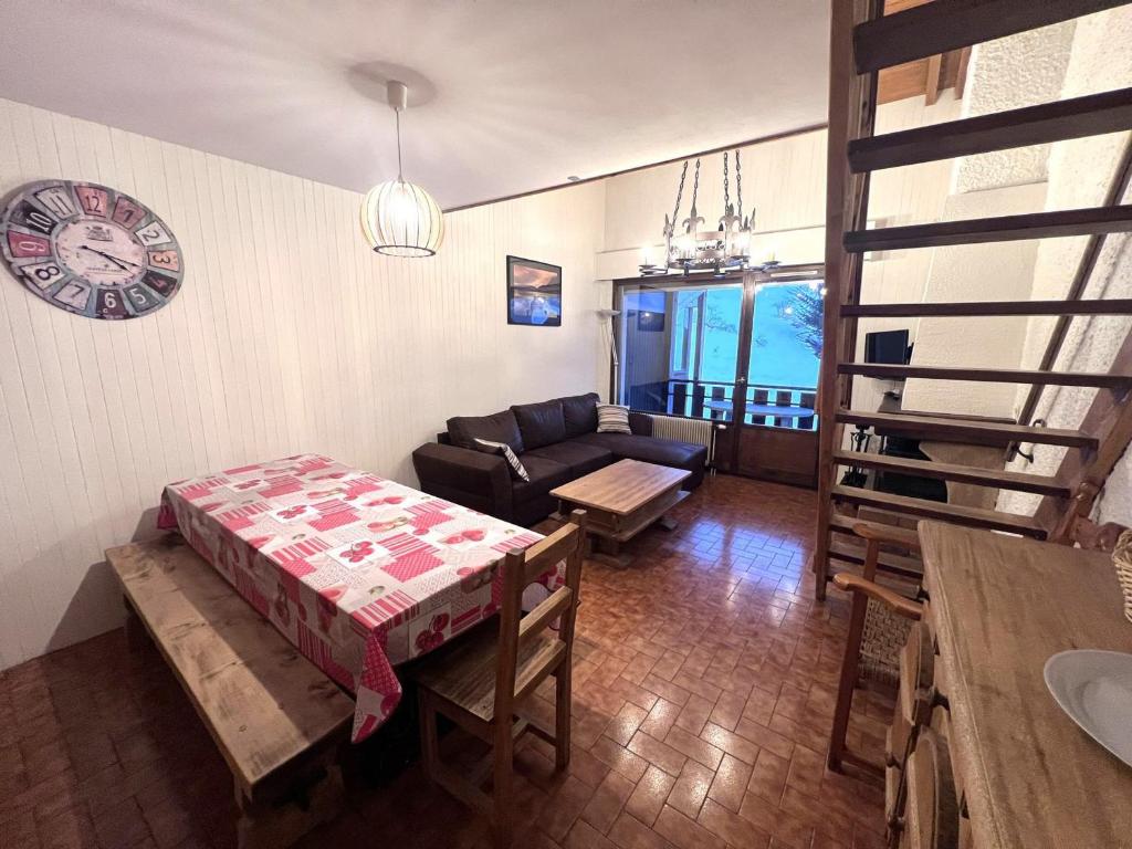 un salon avec un canapé et une horloge au mur dans l'établissement Appartement 2 ch, centre de La Clusaz, 8 pers, proche pistes et activités - FR-1-437-55, à La Clusaz