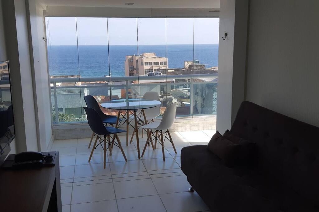 uma mesa e cadeiras num quarto com vista para o oceano em Apartamento Barra vista Mar em Salvador