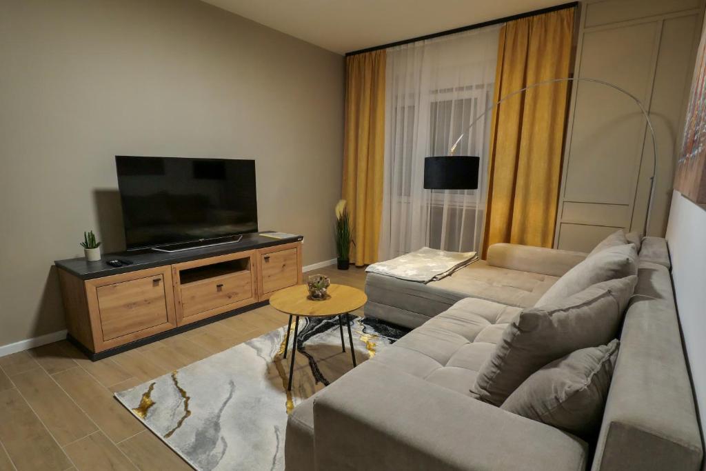 a living room with a couch and a flat screen tv at Apartman Cesarac in Osijek
