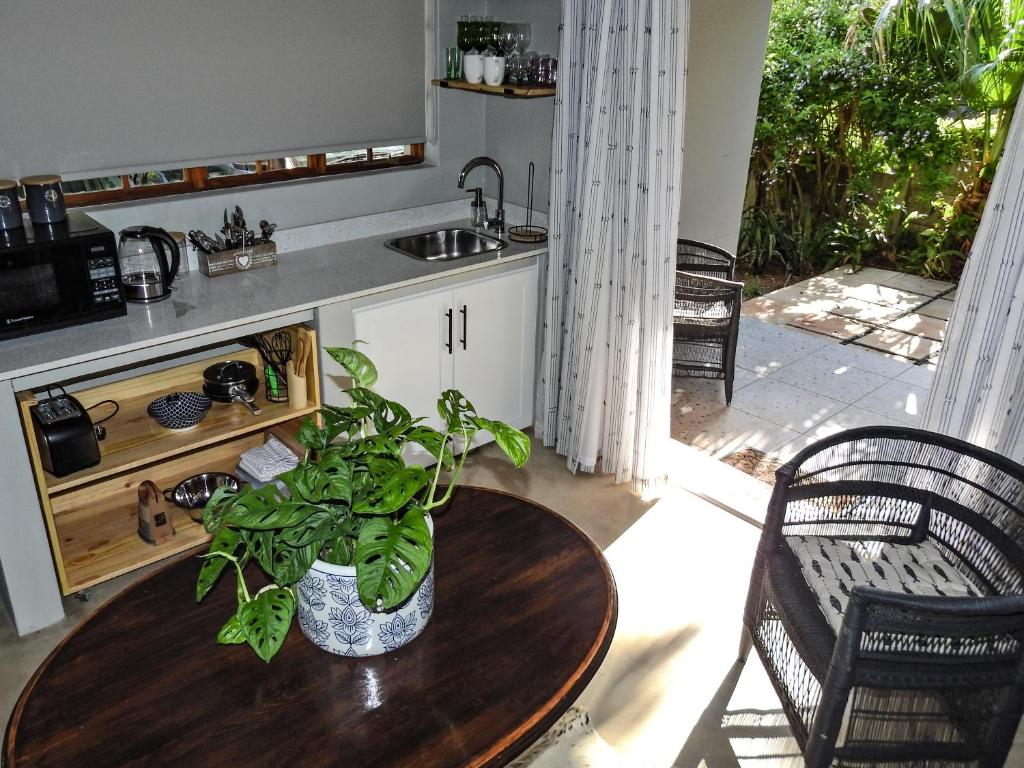 eine Küche mit einem Tisch und einer Topfpflanze darauf in der Unterkunft 41 South in Mtunzini