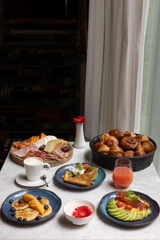 a table topped with plates of food and bread at Hotel Le Place d'Armes - Relais & Châteaux in Luxembourg