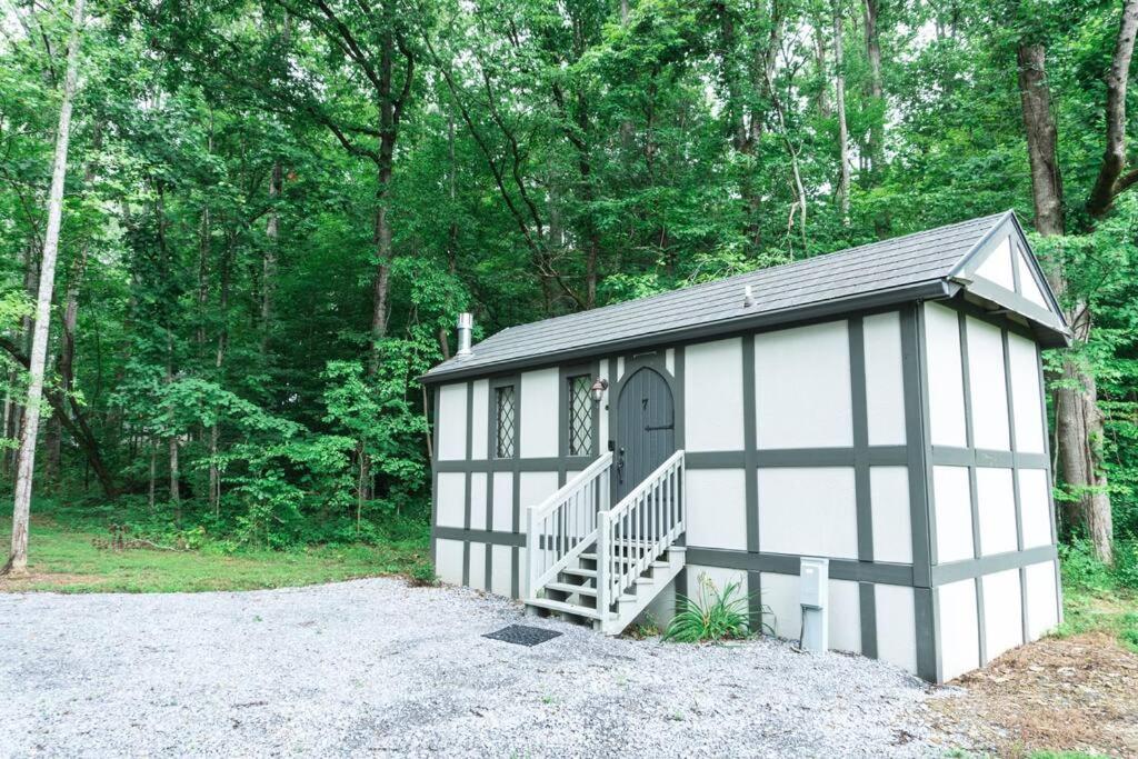 eine kleine weiße und schwarze Garage mit einer Tür und einer Treppe in der Unterkunft Tiny Home Cottage Near the Smokies #7 Tilly in Sevierville