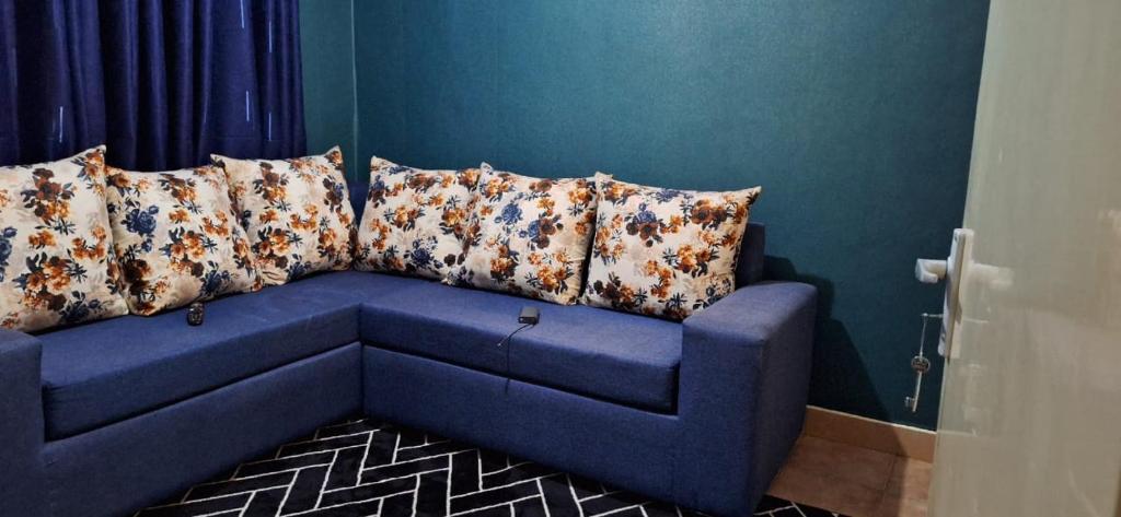 a blue couch with pillows on it in a room at Lakeside apartment in Kisumu
