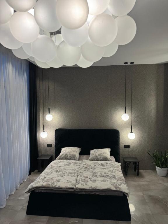 una camera da letto con un grande letto e un soffitto con luci di Apartment Delmar Lux ЦЕНТР a Dnipro