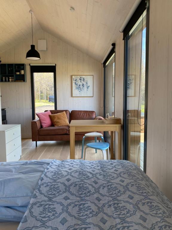 een slaapkamer met een bed, een tafel en een bank bij Bjarmaland Cottages in Selfoss