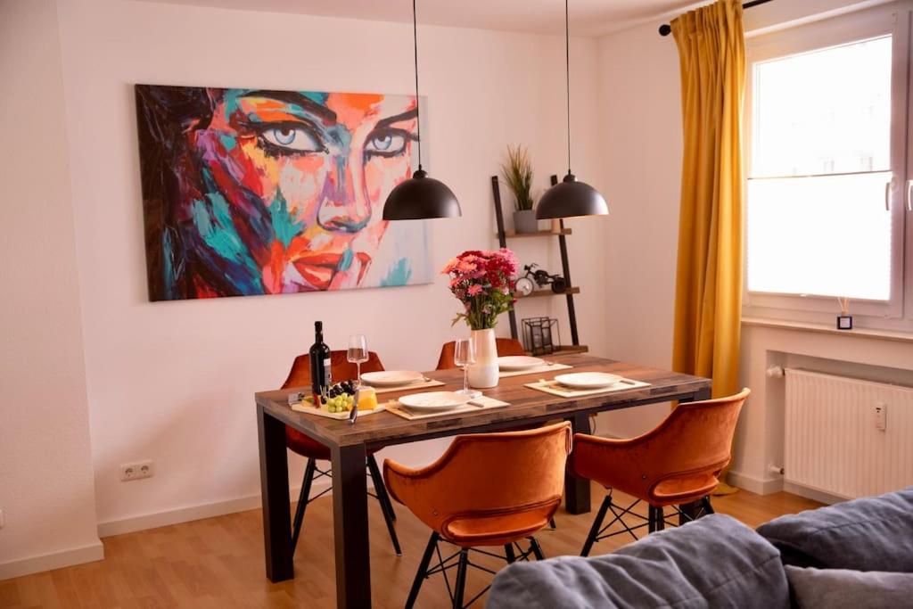 埃森的住宿－Stilvolles Apartment - Messe Rü Innenstadt，餐桌、椅子和墙上的绘画