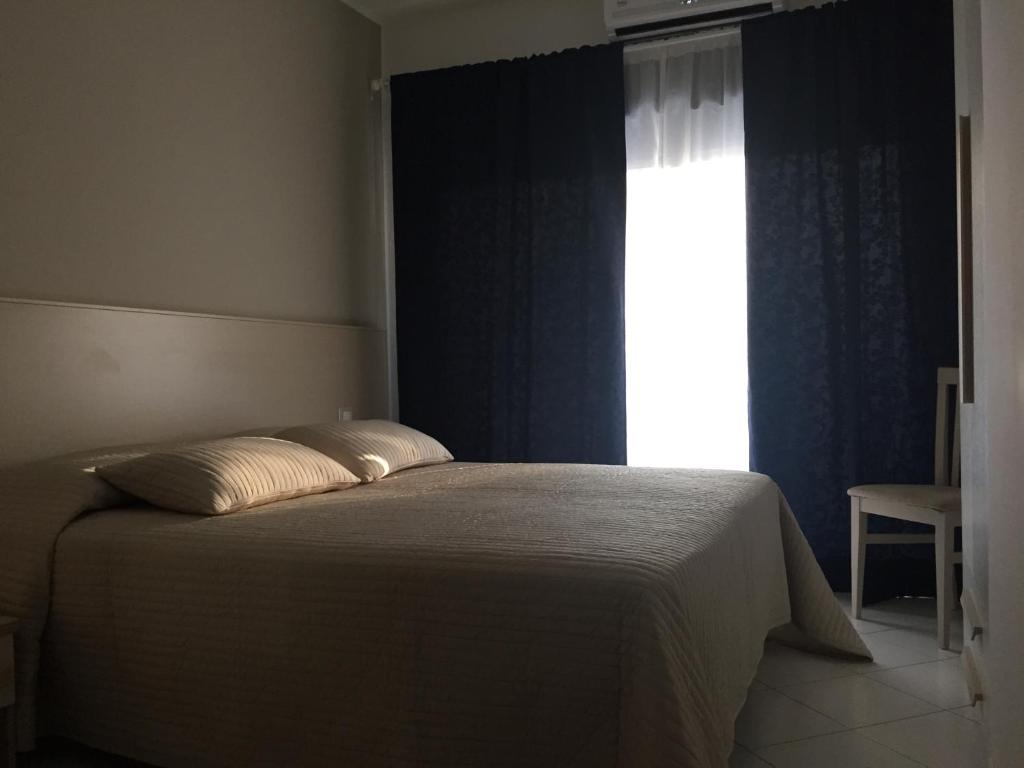 um quarto com uma cama grande e uma janela em Appartamento 403 em Messina