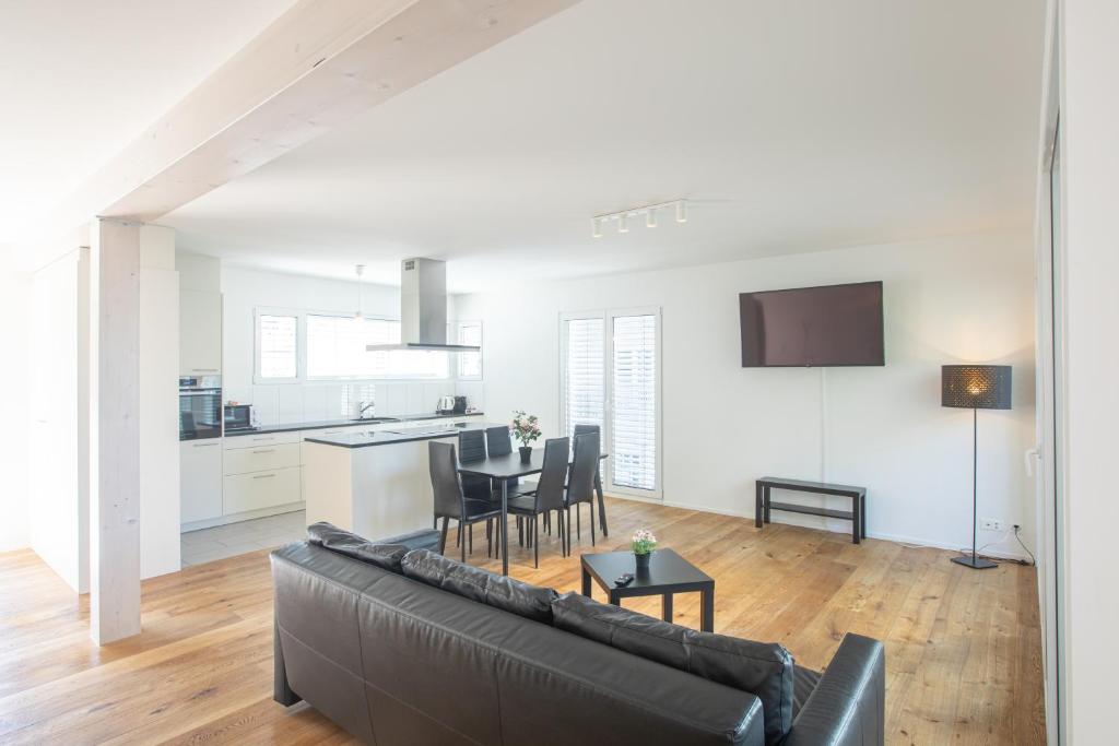 a living room with a black couch and a kitchen at GOOD NIGHT Apartments in Basel