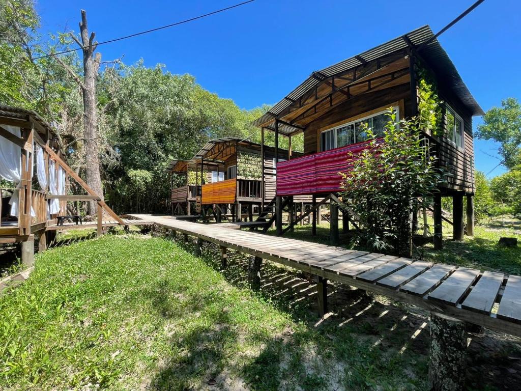 a log cabin with a wooden walkway in front of it at Mostrotel - Tu Hotel en el Delta in Tigre