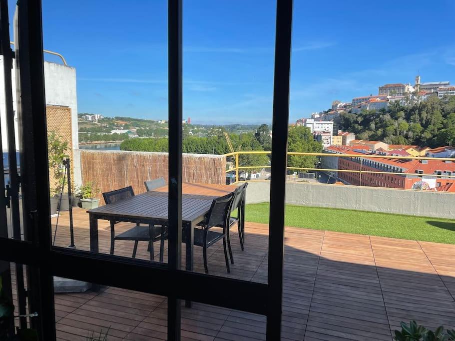 a view of a table and chairs from a window at Penthouse Terraço de Coimbra in Coimbra