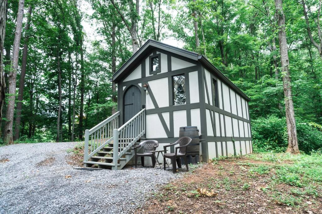 a small black and white shed with a bench and stairs at Tiny Home Cottage Near the Smokies #8 Helga in Sevierville