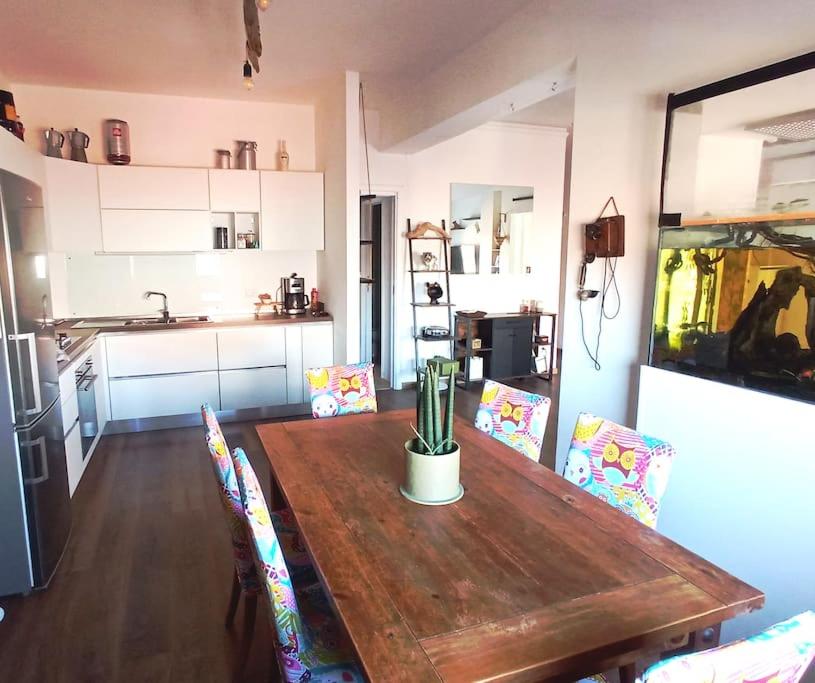 Il dispose d'une cuisine avec une table et des chaises en bois. dans l'établissement Rooftop Appia antica,silenzioso riservato two bedrooms two bathrooms, à Rome