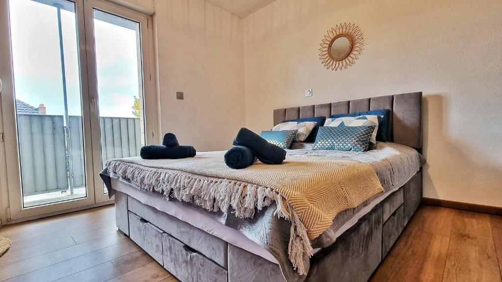 a bedroom with a large bed with a large window at Le City View - Calme - Moderne - Balcon - RelaxBNB in Illzach