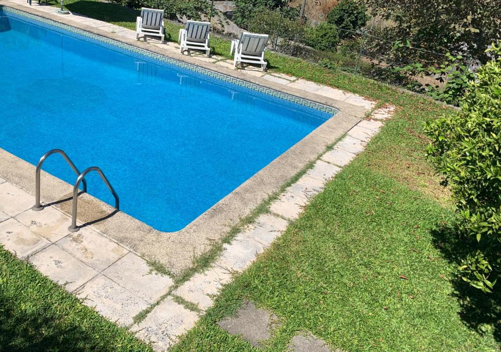- une piscine avec deux chaises dans la cour dans l'établissement Casa d'Avó Maria - Alojamento rural familiar, à Marco de Canavezes