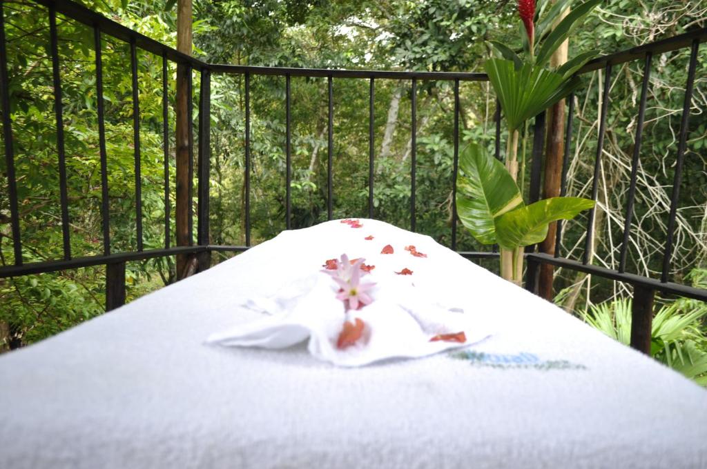 een tafel met een witte tafeldoek met bloemen erop bij Acuali EcoHostal in Capurganá