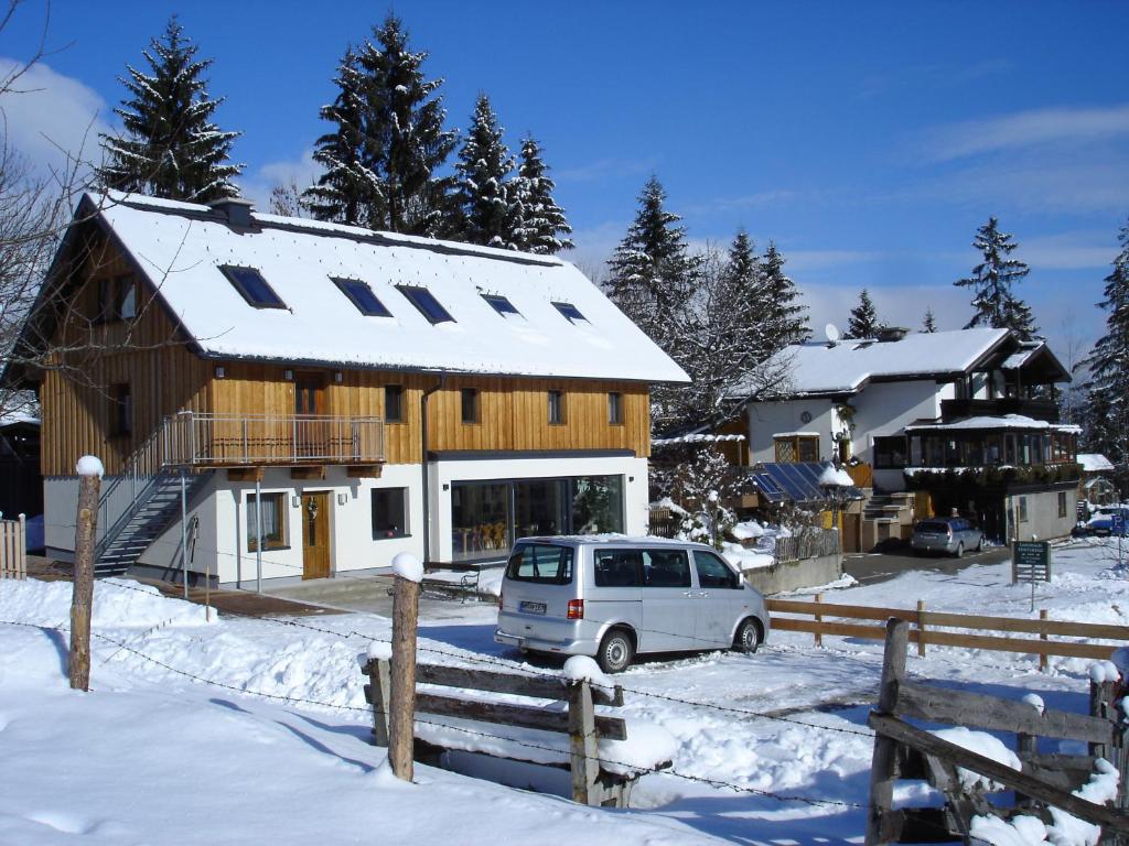 een auto geparkeerd voor een huis in de sneeuw bij Appartements Scharzenberger und Hinteregg in Schladming