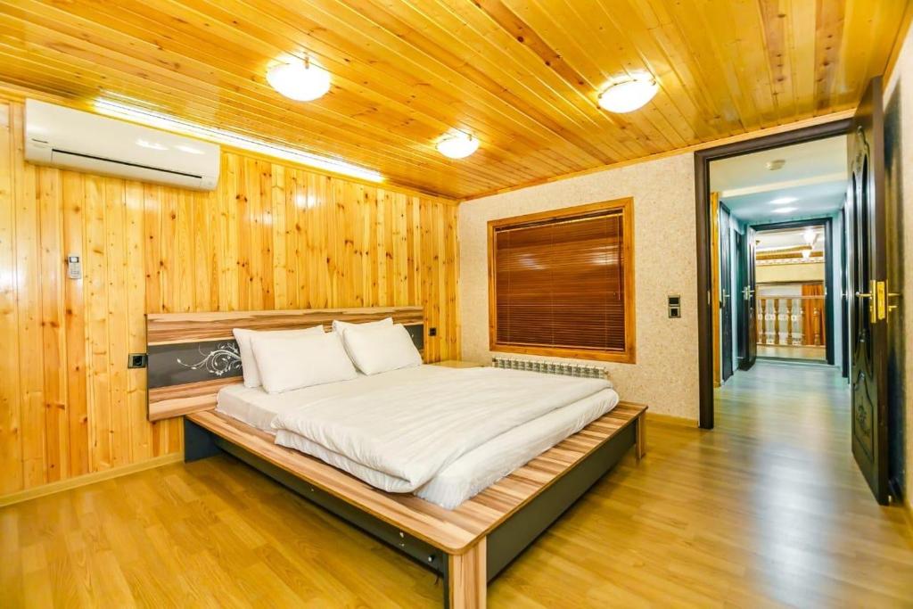 een bed in een kamer met een houten muur bij View Nizami Street Chapman Taylor Baku in Baku