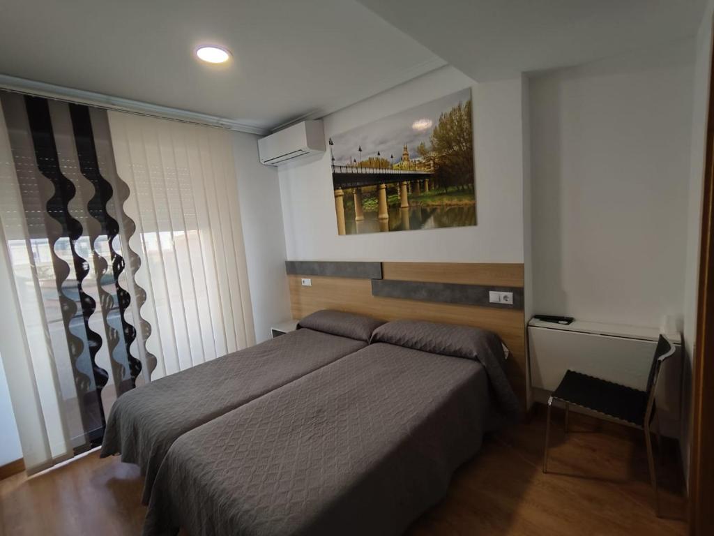 1 dormitorio con 1 cama y una pintura en la pared en Hostal Rioja Condestable en Logroño