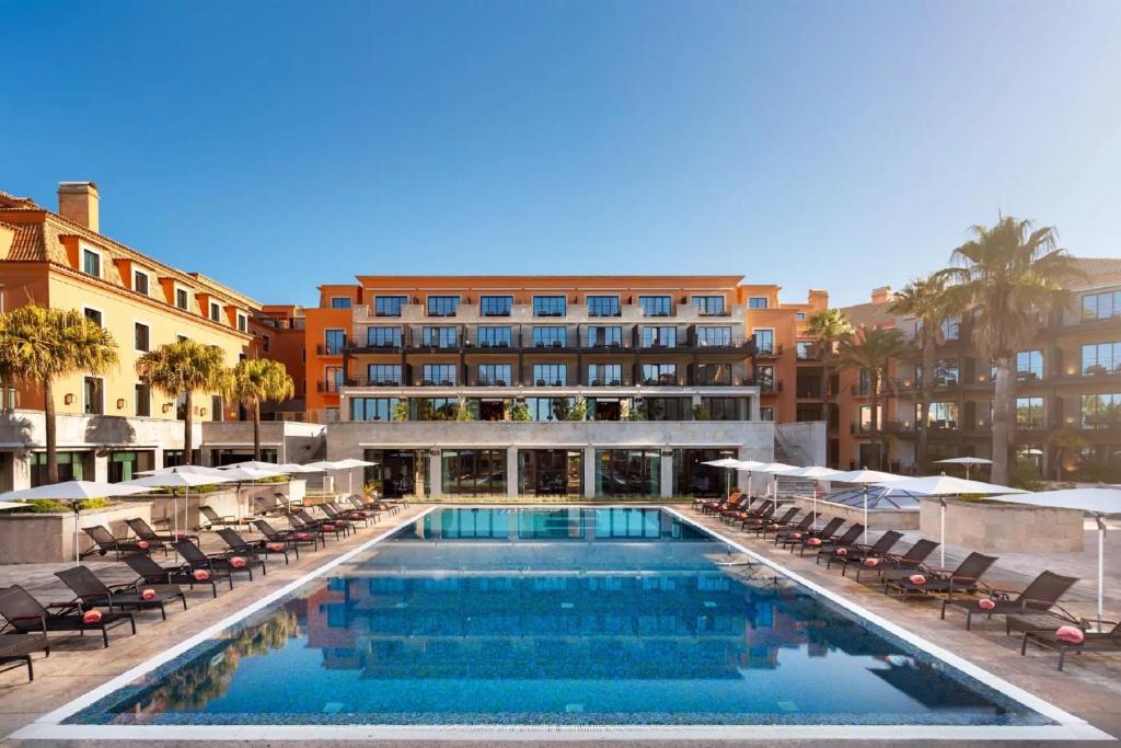 duży basen z krzesłami i hotel w obiekcie Grande Real Villa Itália Hotel & Spa w mieście Cascais