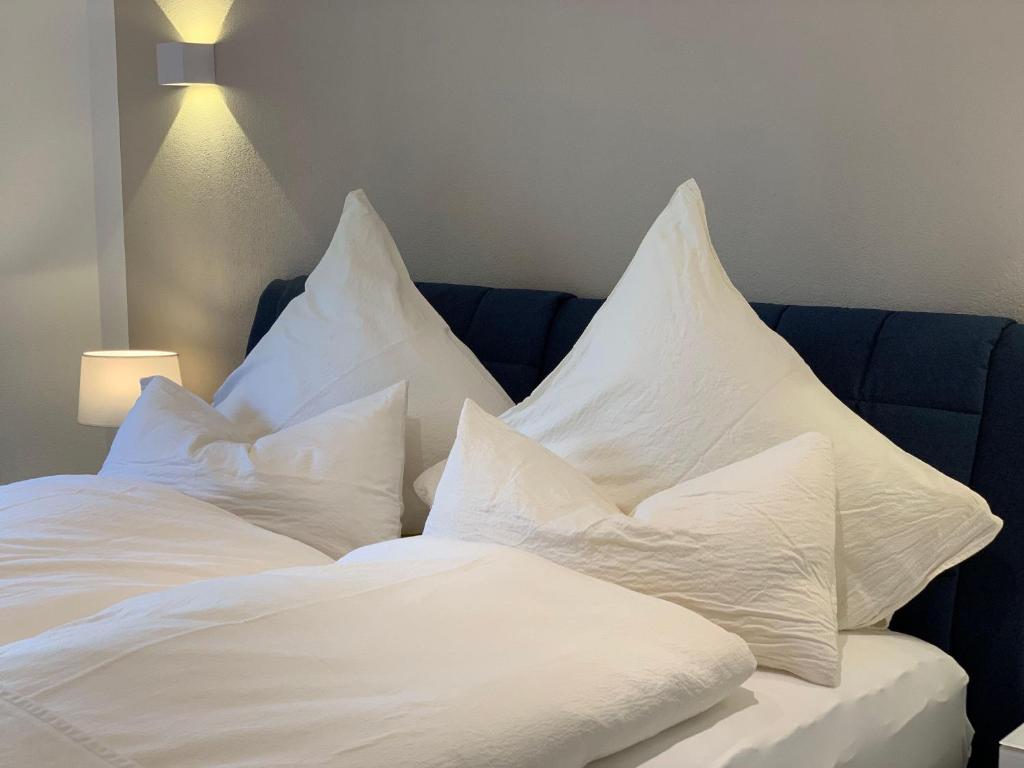 - une pile d'oreillers blancs assis sur un lit dans l'établissement Luxusferienwohnung-|-Koehnke-7, à Hahnenklee