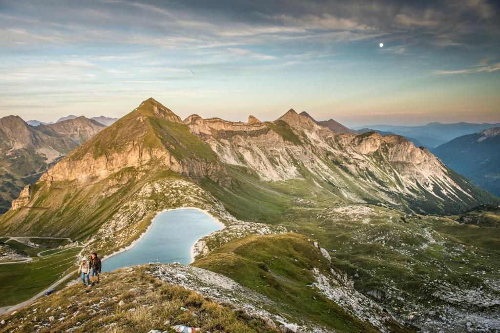 two people standing on top of a mountain with a lake at Pension Weinberger in Obertauern