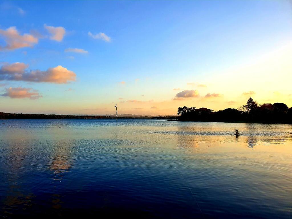 a lake with a person in the water at sunset at Cabana's on Gatun Lake in Arenosa in Arenosa