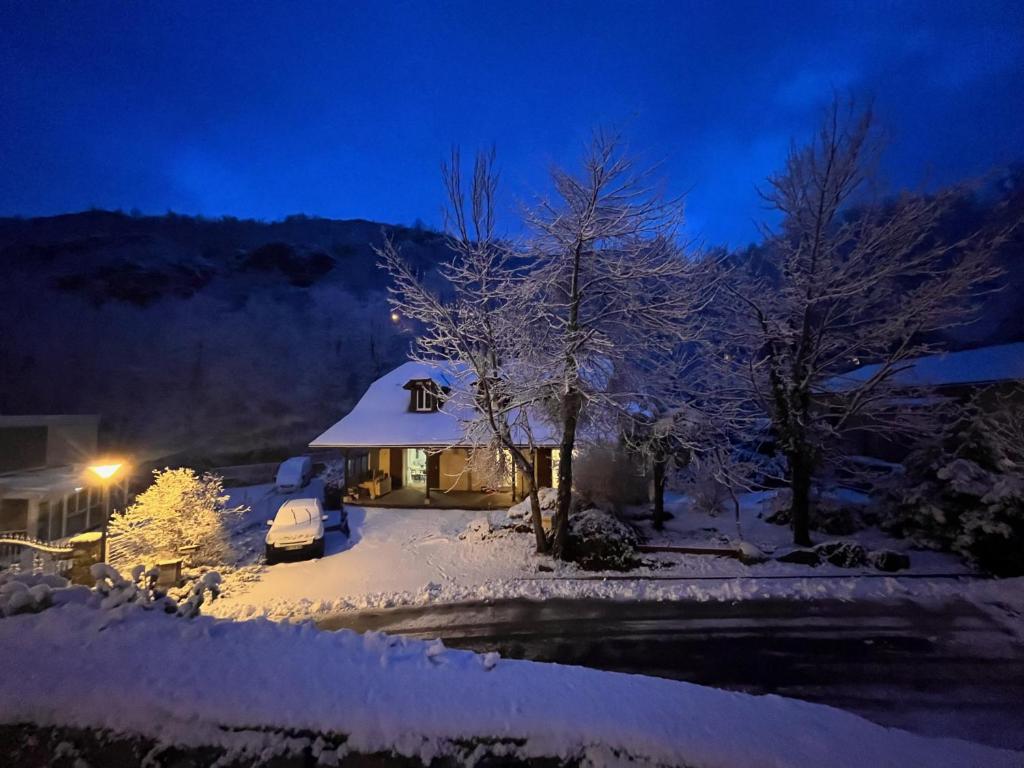 una casa cubierta de nieve por la noche en Chalet d’Ax Pyrénées, en Ax-les-Thermes