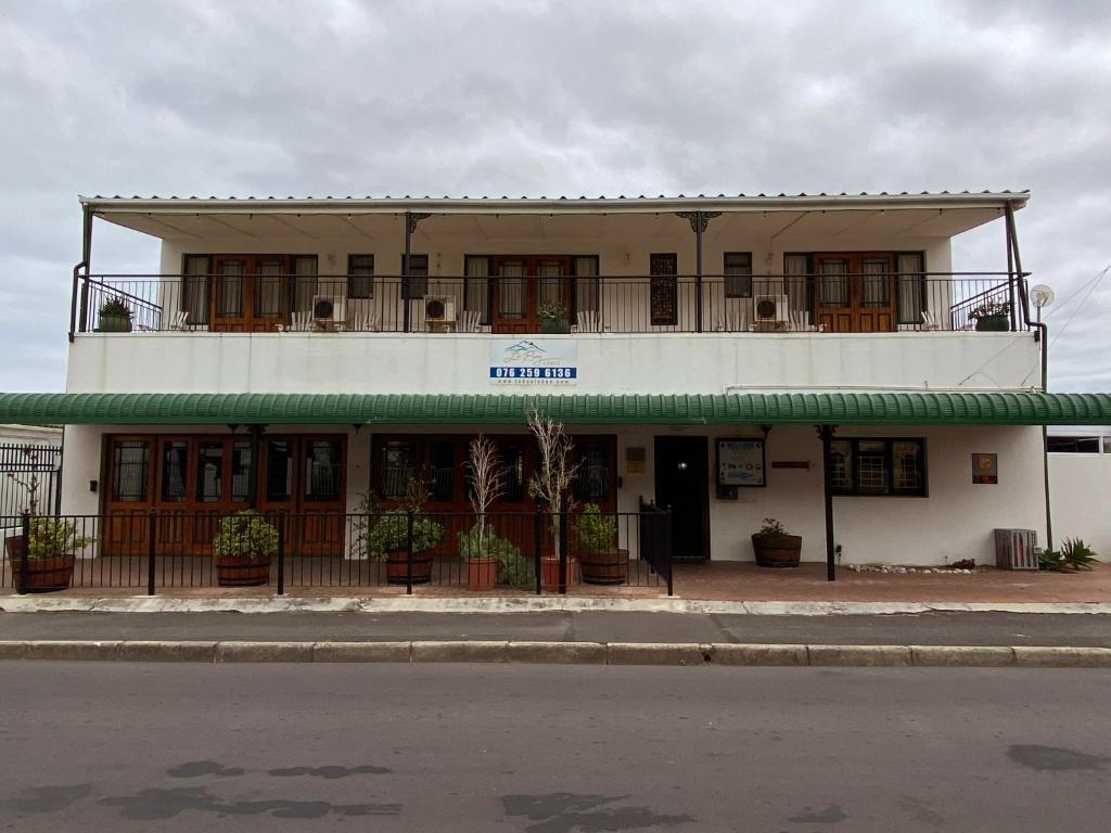 een gebouw met een balkon erboven bij Le Bay Lodge in Gordonsbaai