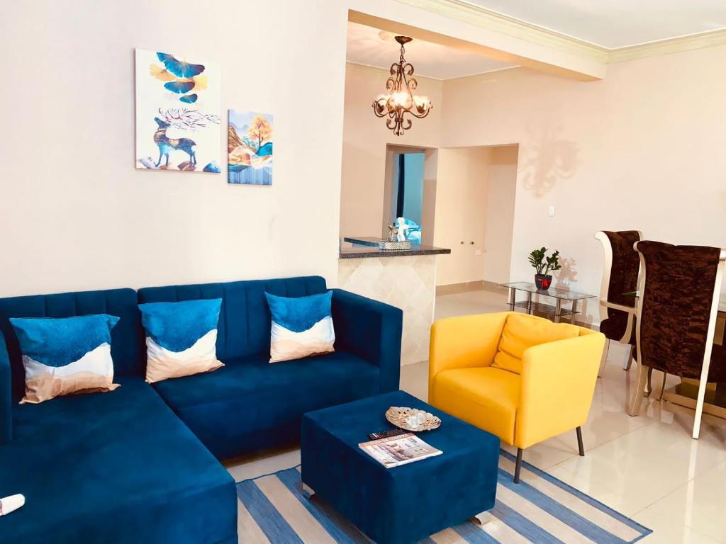 salon z niebieską kanapą i żółtym krzesłem w obiekcie Grande y acogedor apartamento cerca de la playa. w mieście Azua de Compostela