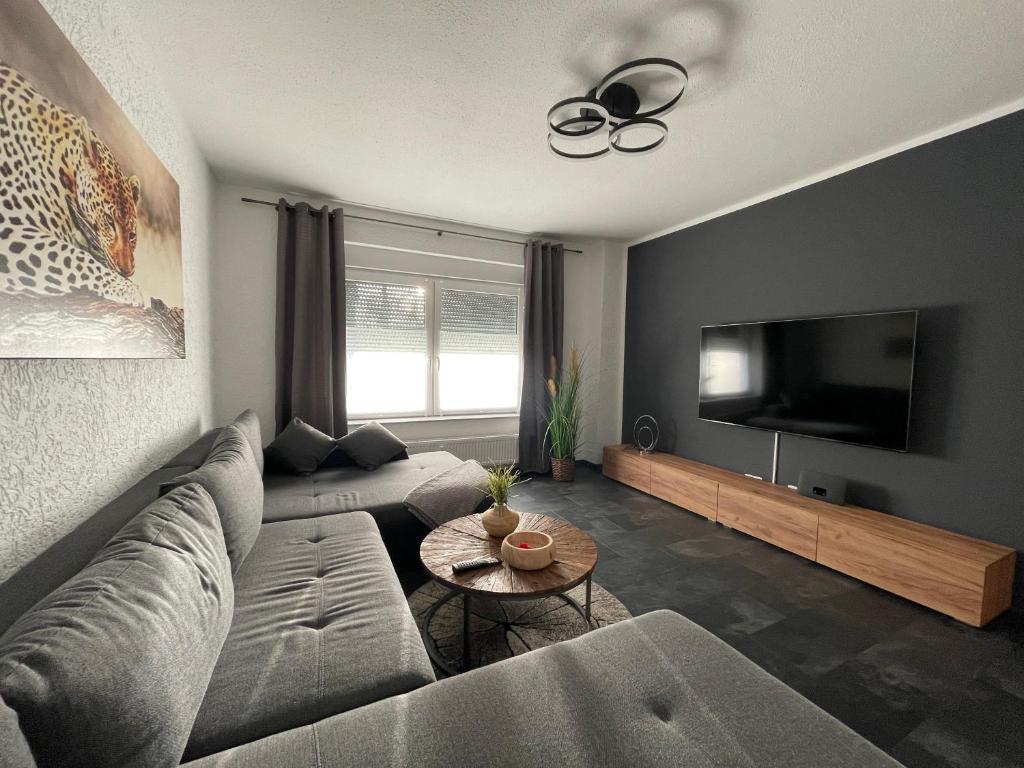 een woonkamer met een bank en een flatscreen-tv bij - Top Ausstattung - Kostenlos Netflix/Wifi/Parken in Gladbeck