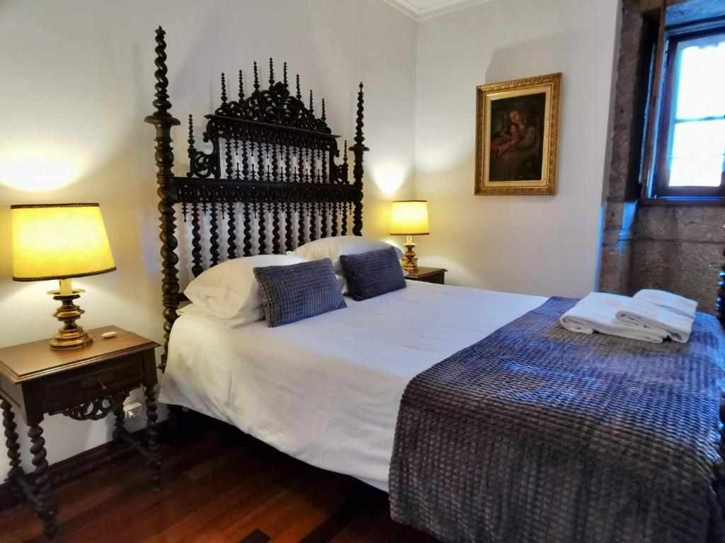 a bedroom with a large bed and two lamps at Casa do Faial - Braga in Braga