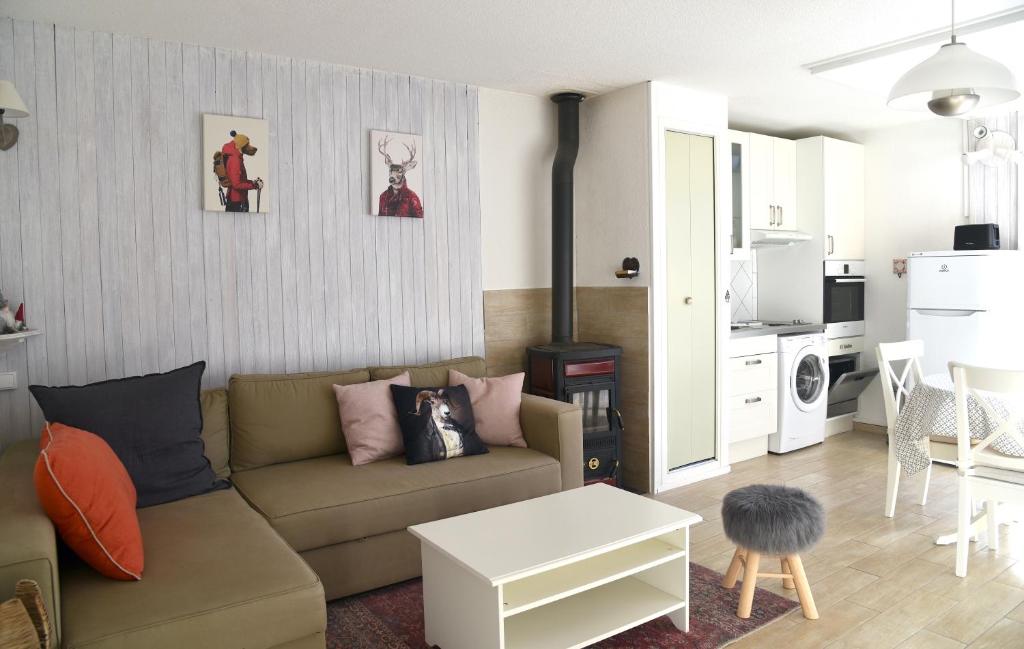 ein Wohnzimmer mit einem Sofa und einer Küche in der Unterkunft Appartement lumineux et calme - La Foux-Mercantour in Allos