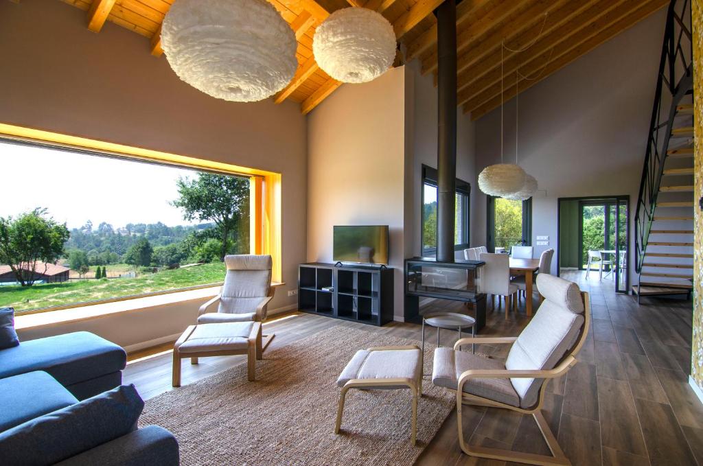 sala de estar con sofá azul y sillas en Espectacular casa con encanto para familias y grupos, en Ourense