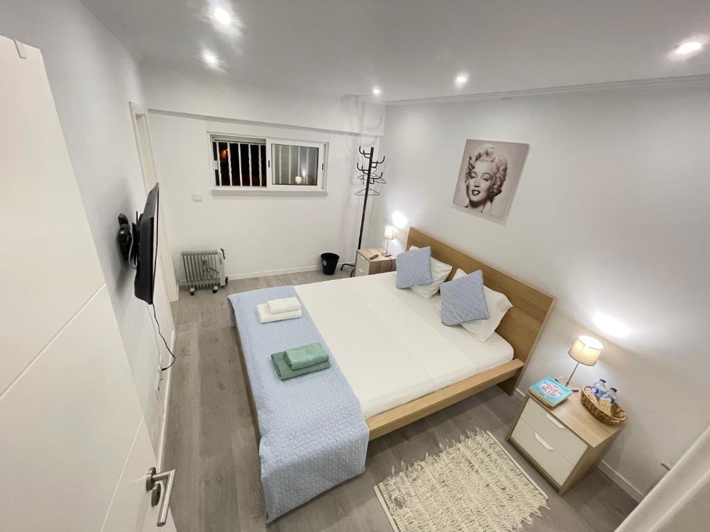 małą białą sypialnię z łóżkiem i kanapą w obiekcie airport room w Lizbonie