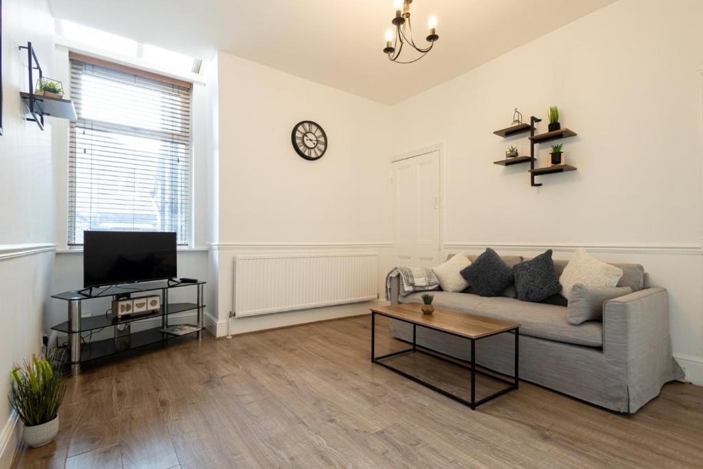 a living room with a couch and a tv at GuestReady - Lovely stay in Manchester in Manchester