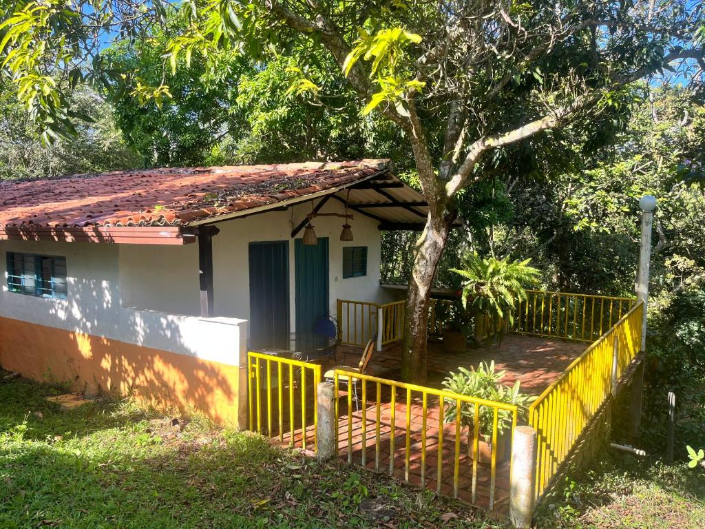 una pequeña casa con una valla amarilla delante de ella en Finca La Esperanza - Cabaña Villa Marujita en Socorro