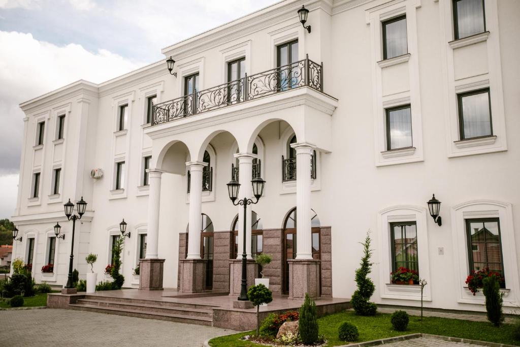 - un bâtiment blanc avec balcon dans l'établissement Hotel Beli Dvor, à Čačak